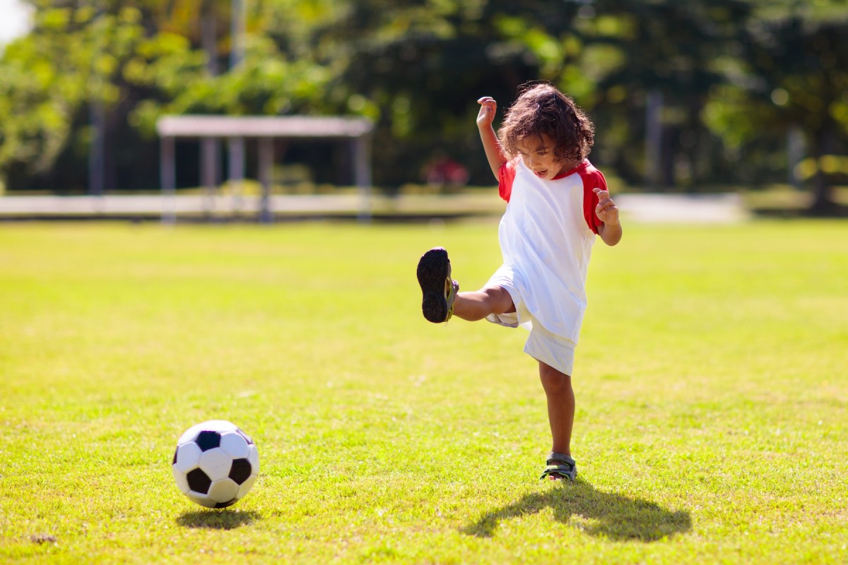 boy kicking soccer football