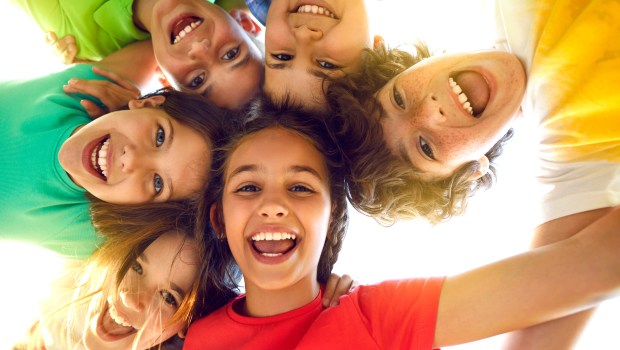 Montón de alegres y adorables niños pequeños jugando juntos y divirtiéndose. Retrato grupal de niños felices
