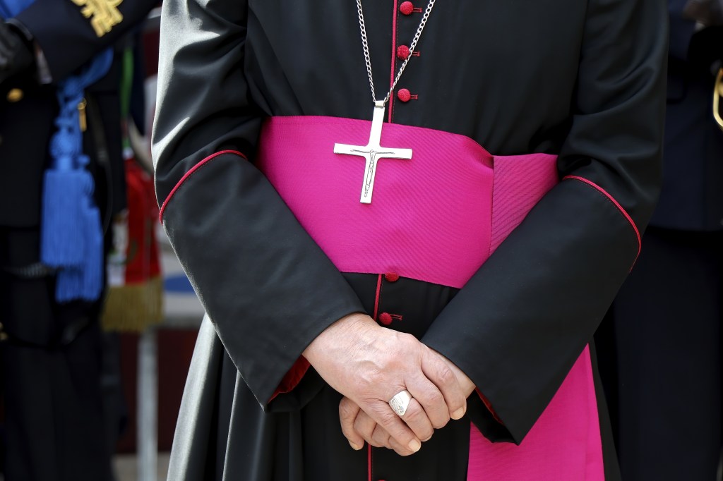 Biskup trzymający złożone ręcę