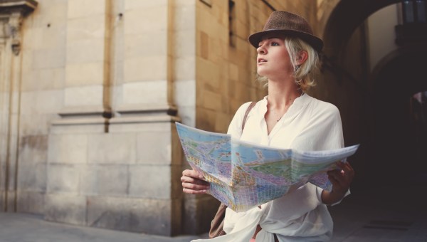Zakłopotana turystka z mapą stoi na ulicy