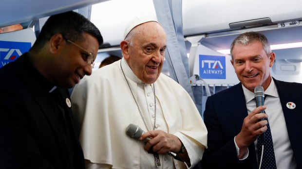 Pope Francis talks to journalists aboard his plane before landing at the Figo Maduro air base in Lisbon to attend the World Youth Day