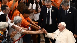 Pope Francis shakes hands with people during his visit to the Serafina parish social centre
