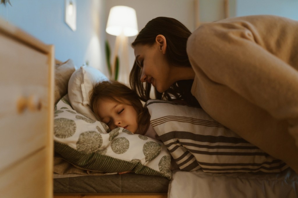the-girl-sleeps-in-bed-mom-came-to-wake-her-up-and-gently-leaned-over-her-shutterstock_1589849437.jpg
