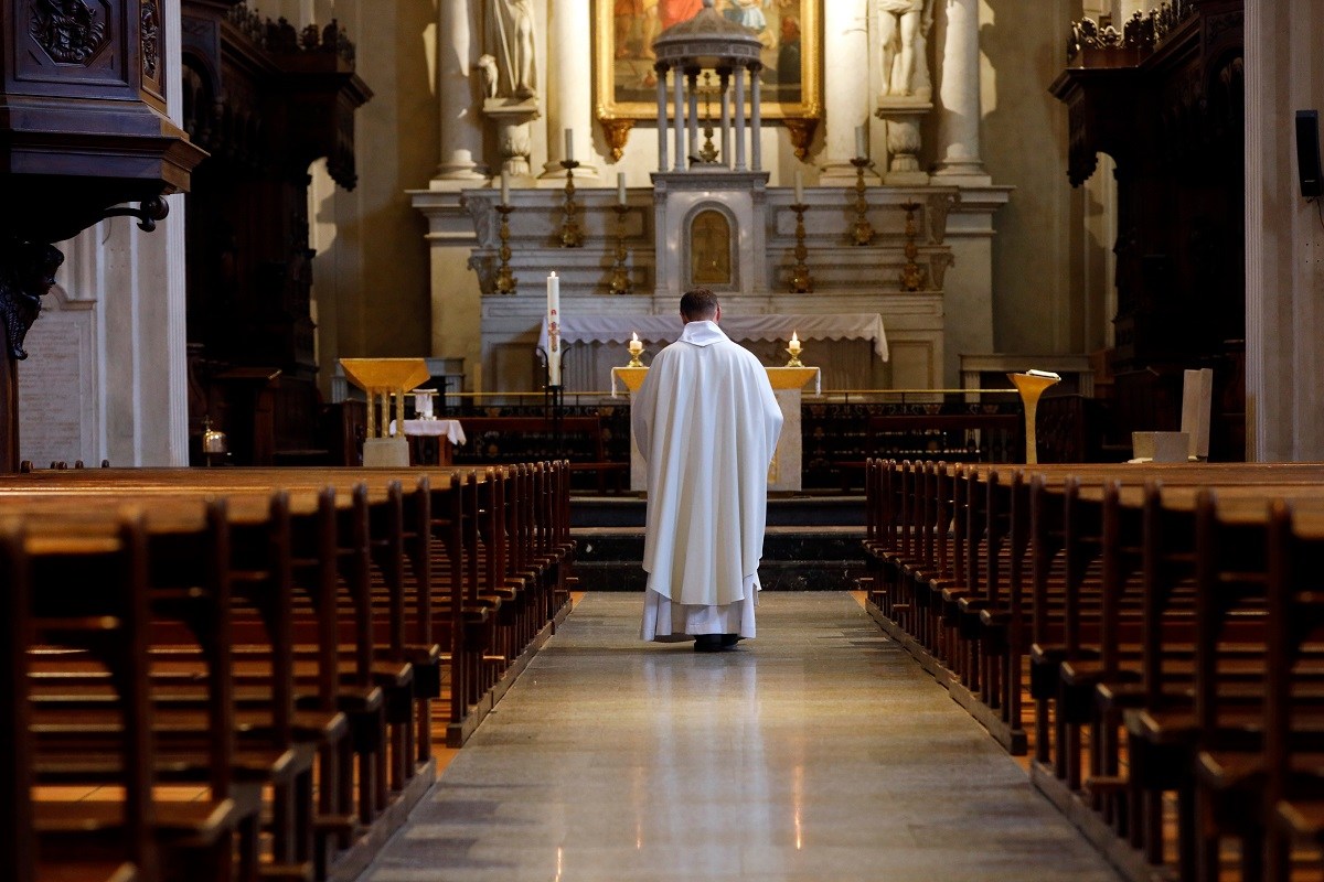 Priest in empty church