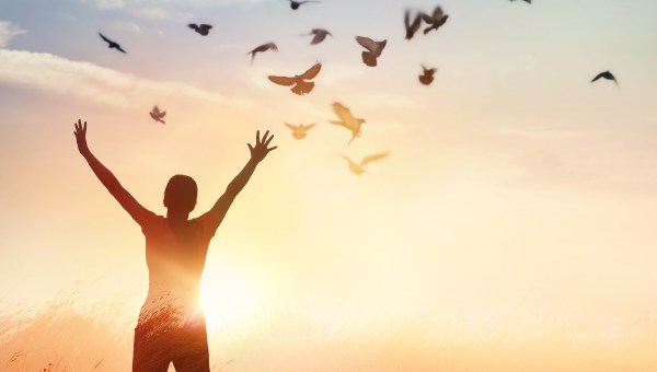 Kobieta unosząca ręce w geście radości i wolności