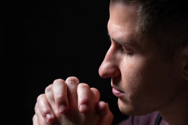 Praying man on a black background