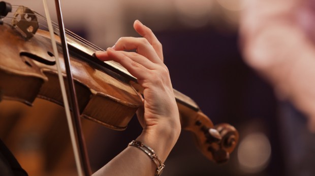 Mãos de uma mulher tocando violino