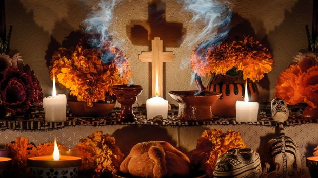 Traditional-day-of-the-dead-altar-with-pan-de-muerto-and-candles-shutterstock.jpg