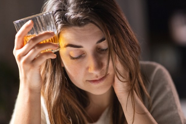 drunk woman or female alcoholic drinking whiskey at home