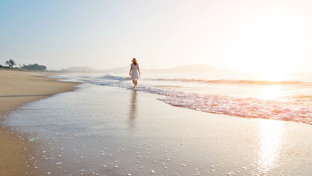 WALKING-BEACH-WOMAN-shutterstock_2313073889