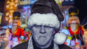 A grumpy guy in Santa cap in front of Christmas lights