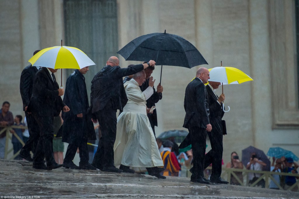 Pope Francis leaves during a heavy storm after his weekly general audience