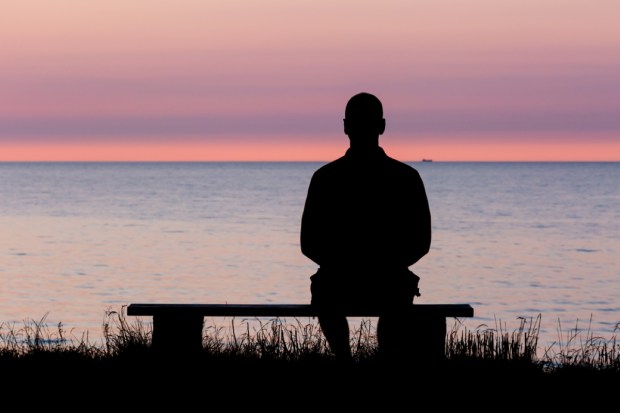 Silhouette of male person against a colorful horizon