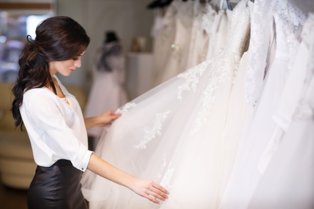 dealer consultant in the background of wedding dresses