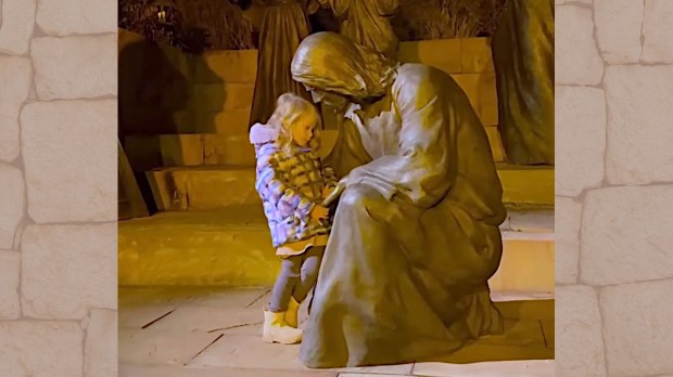 Little girl with Jesus statue