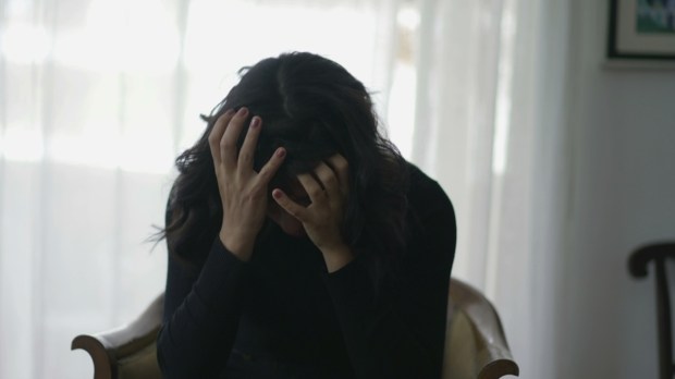 Woman covering face in shame suffering from emotional pain