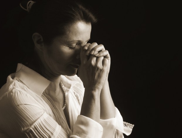 Devout woman with eyes closed in prayer