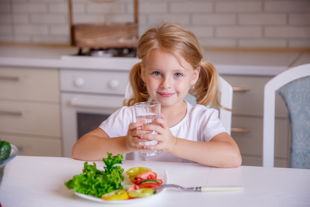 Girl eating veggies drinking water