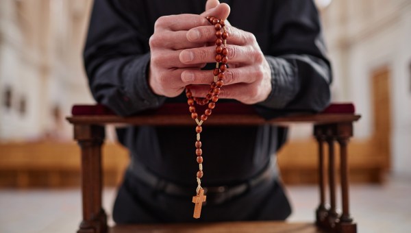 Mężczyzna modlący się na różańcu