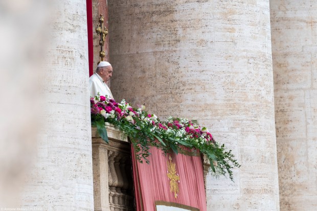 Pope Francis waves from the central loggia of St. Peter's basilica during the Easter 'Urbi et Orbi' message and blessing to the City and the World as part of the Holy Week celebrations
