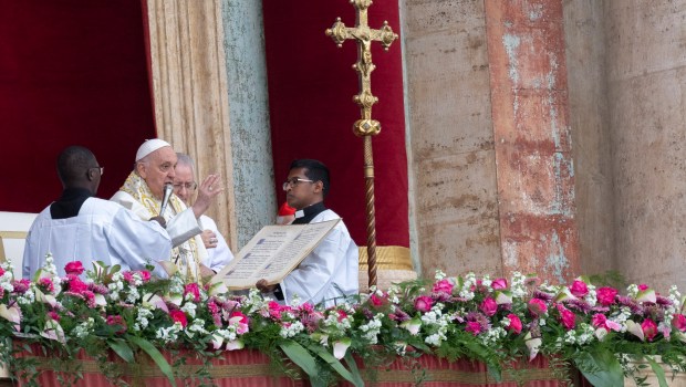 Pope Francis waves from the central loggia of St. Peter's basilica during the Easter 'Urbi et Orbi' message and blessing to the City and the World as part of the Holy Week celebrations