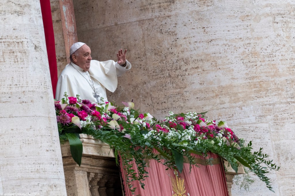 Pope Francis waves from the central loggia of St. Peter's basilica during the Easter 'Urbi et Orbi' message and blessing to the City and the World as part of the Holy Week celebrations