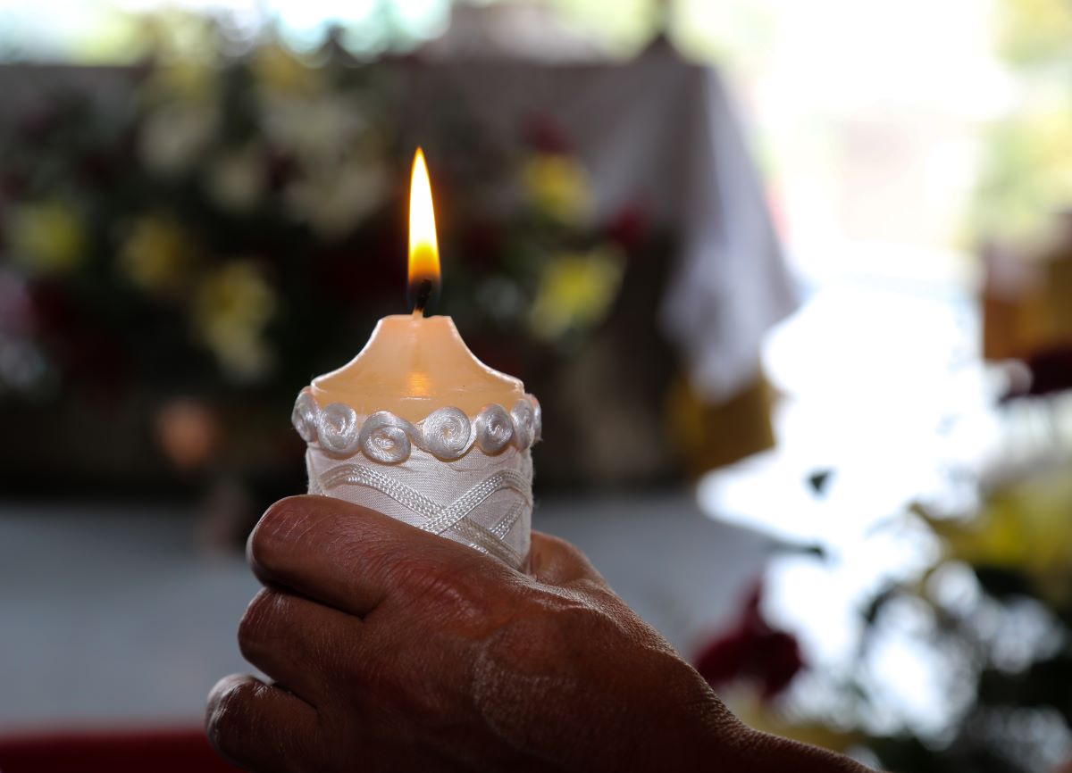 paschal-candle-in-adult-hand-shutterstock_1384116209