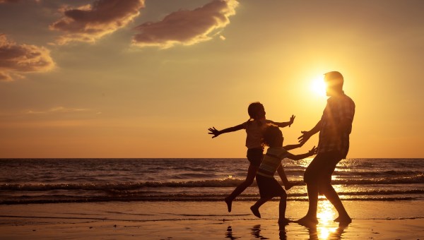Dad with kids at beach sunset