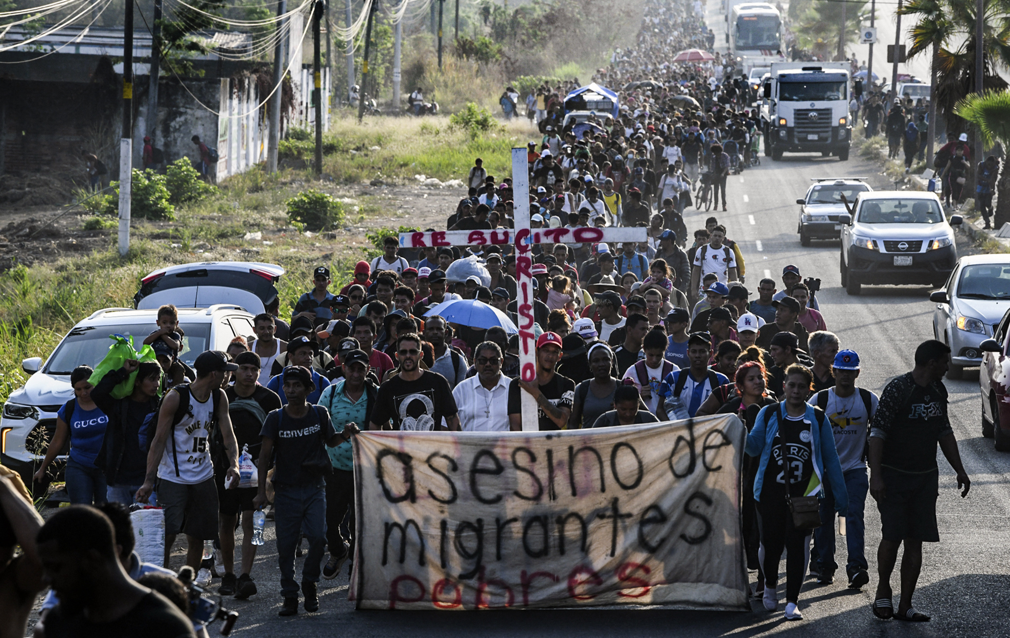 migrants carry a cross border between Mexico and the United States