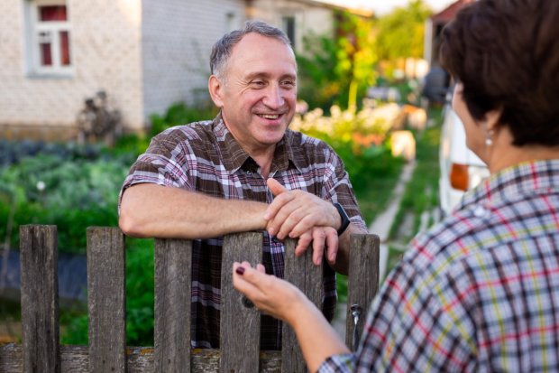 Neighbors talking across fence