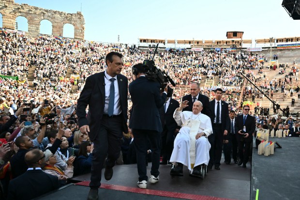 Pope Francis waves as he arrives at the Arena during a visit in Verona, on May 18, 2024.