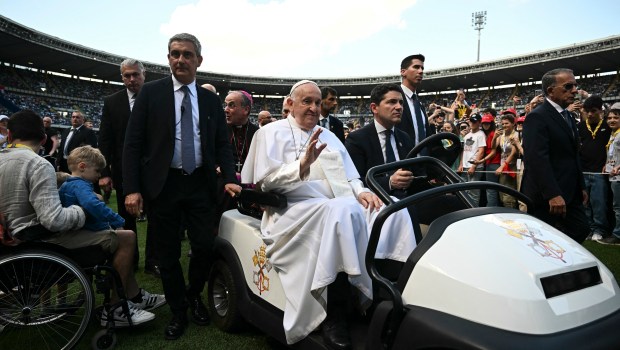 Pope Francis greets people as he arrives to lead a mass at the Bentegodi stadium as part of a visit in Verona, on May 18, 2024.