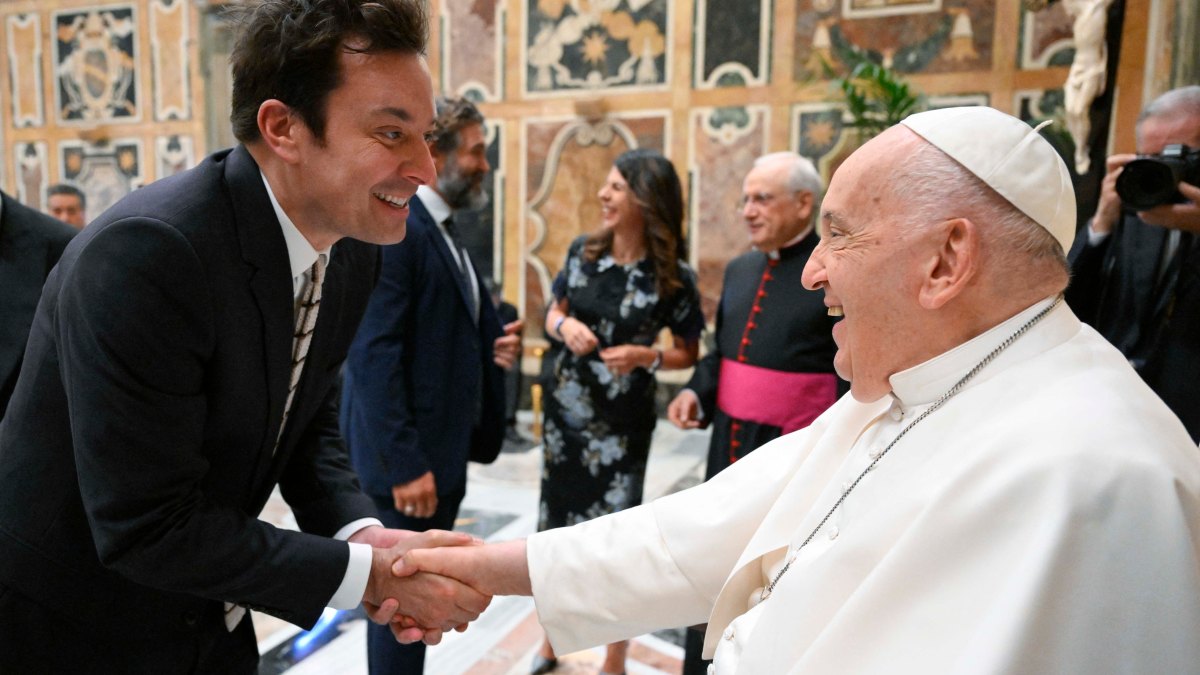 This photo taken and handout on June 14, 2024 by The Vatican Media shows Pope Francis shaking hand with US actor Jimmy Fallon as part of an audience with comedians in The Vatican.
