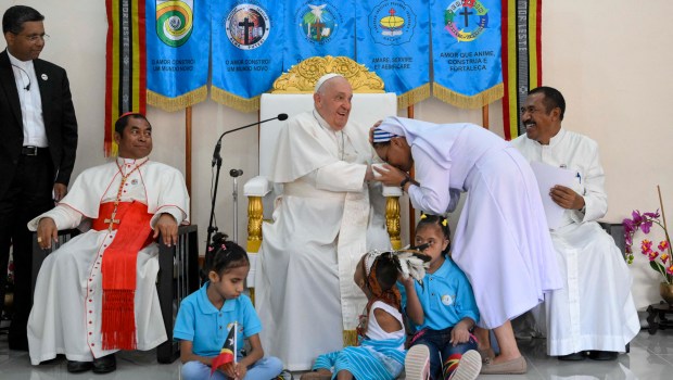 Pope Francis (C) blesses a nun during a visit for children with disabilities at the Irmas Alma school in Dili.