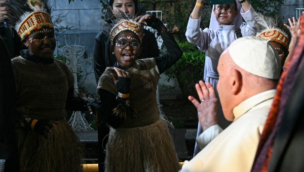 Pope Francis (R) is welcomed as he arrives at Grha Pemuda youth centre in Jakarta on September 4, 2024.