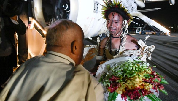 Pope Francis is greeted upon arrival at the Port Moresby International airport.