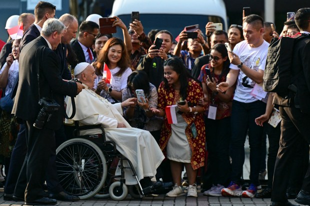 Pope Francis greets worshipers as he arrives at the Jakarta Cathedral in Jakarta on September 4, 2024.