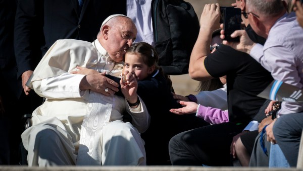 A young girl hugs Pope Francis at the conclusion of his general audience in St. Peter's Square, Vatican, October 30, 2024.