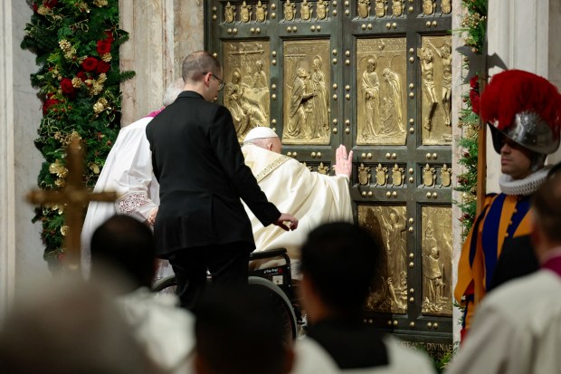 Pope Francis (C) opens the Holy Door of St Peter's Basilica, during a special ceremony to mark the launch of the Jubilee 2025