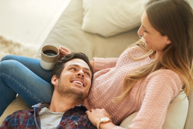 Coffee, relax or happy couple on sofa in home living room together with love, support or trust