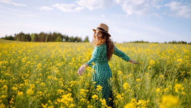 Happy woman walking in flowering field