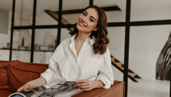 Happy brunette woman in white oversized shirt