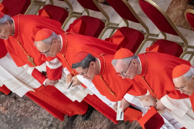 cardinals paying their respects and walking next to the coffin of late Pope Francis at the St Peter's Basilica, during a ceremony following the procession of the late Pope's coffin from the chapel of Santa Marta to St Peter's Basilica in The Vatican