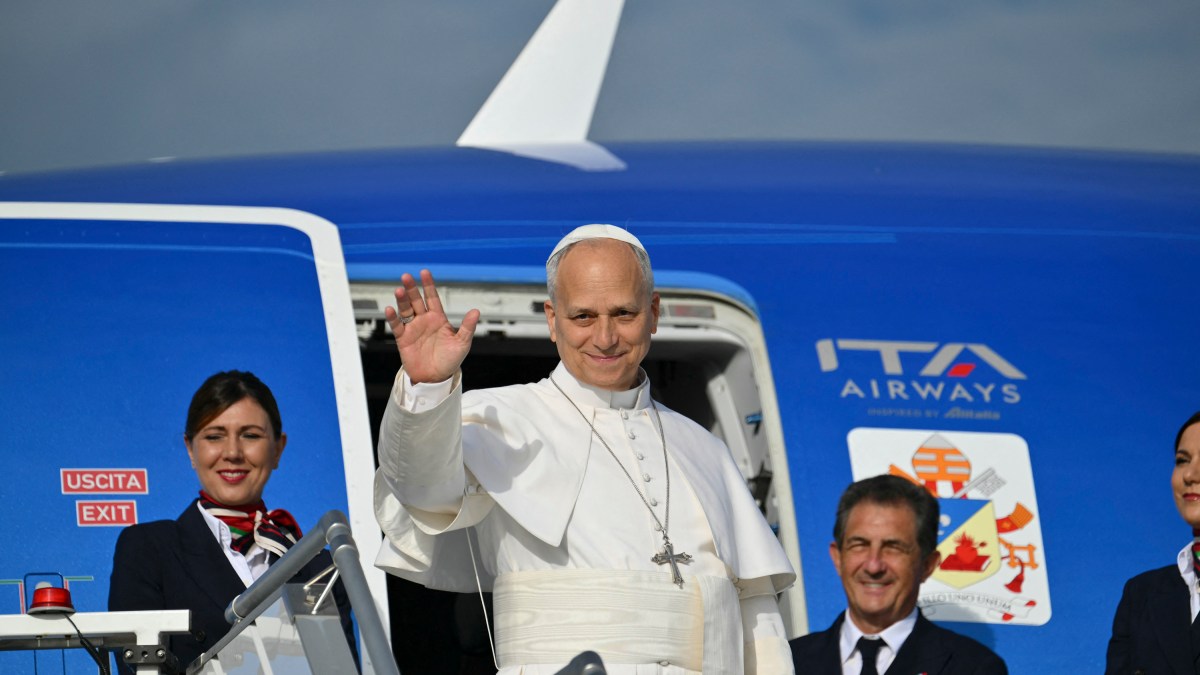 Pope Leo XIV salutes as he prepares to board his plane heading to Madrid at Rome's Fiumicino airport
